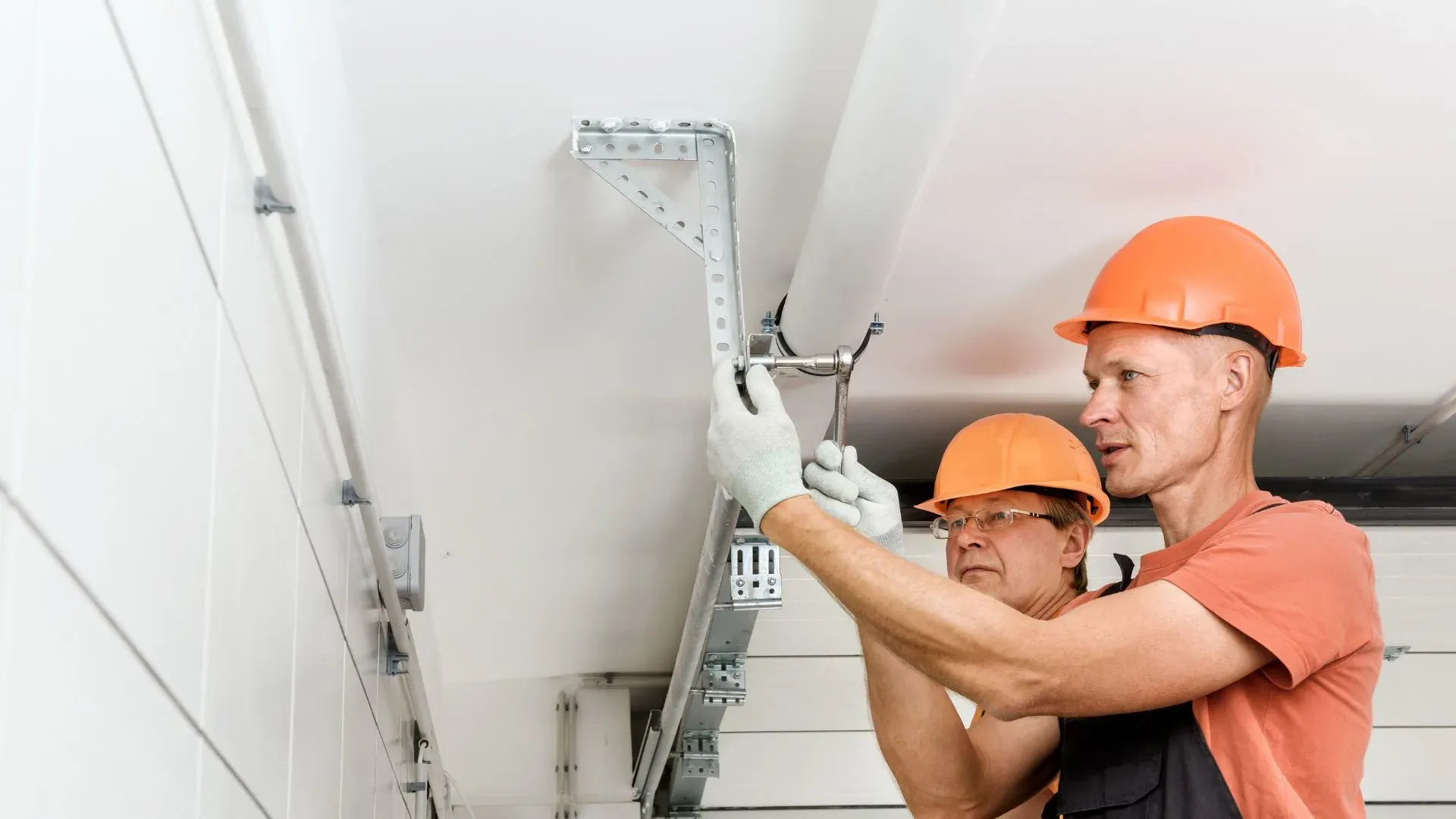 Professional garage door repair technician working on residential garage door