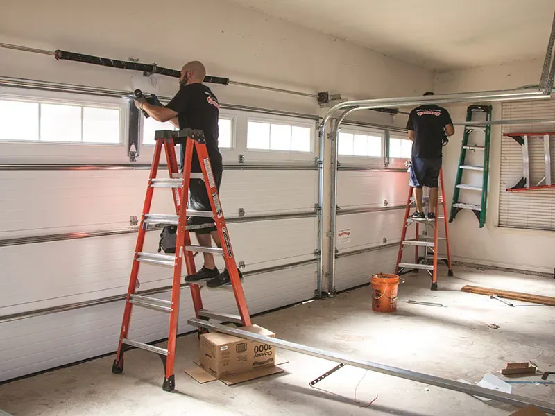 Professional garage door repair technician working on residential garage door